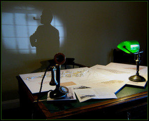 An author jauntily smoking his pipe in his office