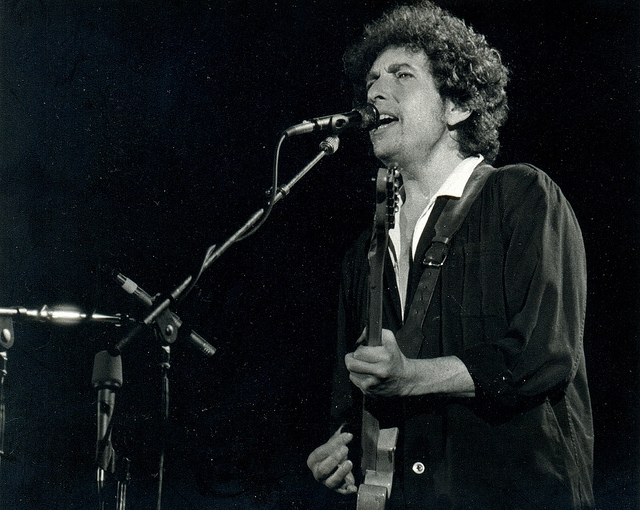Bob Dylan singing and playing guitar