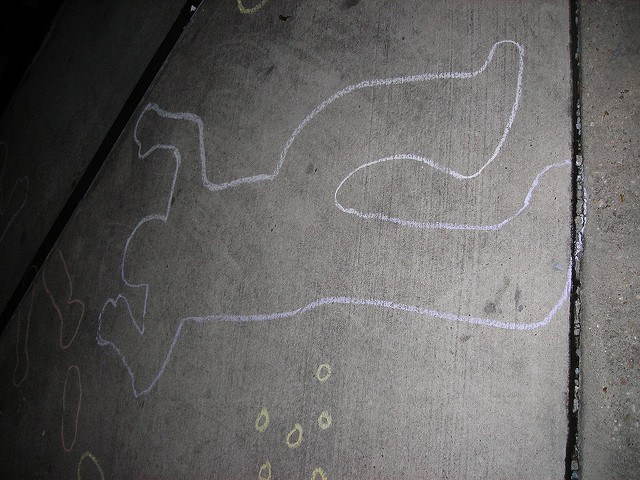 chalk outline of a body, with outlines of bullet casings nearby