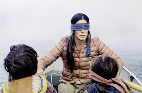 An iconic promo shot from 'Bird Box.' That's Sandra Bullock at the oars with Julian Edwards , left, and Vivien Lyra Blair. Image: Netflix