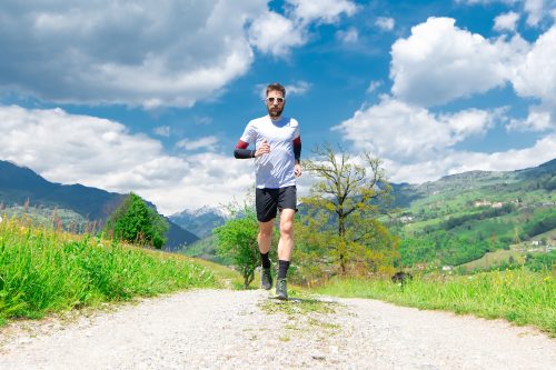 Marathon runner trains in a mountain dirt road