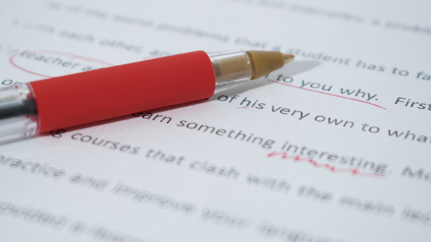 red pen on paper with printed words and red correction marks