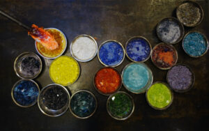 This photo shows colorful glass chips (one color per bowl) that a glass blower will use to create something beautiful.