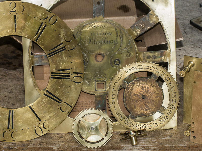 A bunch of beautiful, old-fashioned, brass clock pieces from a grandfather clock.