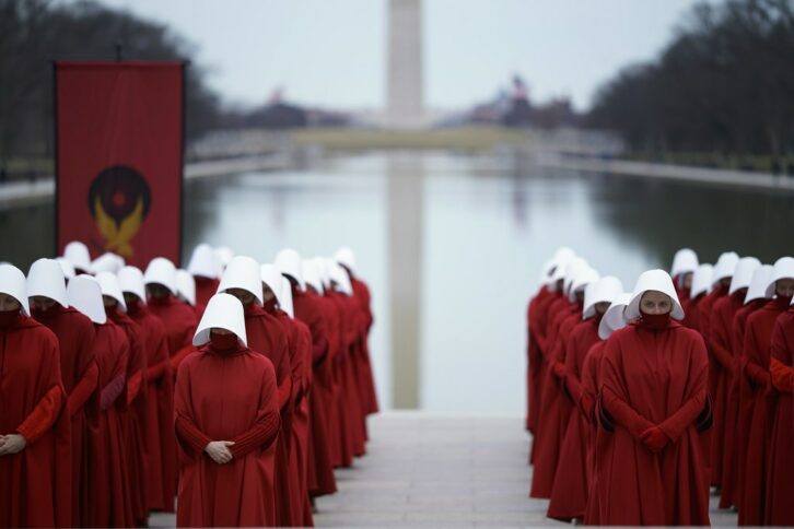 Handmaids in front of the Washington Monument and the Reflecting Pool