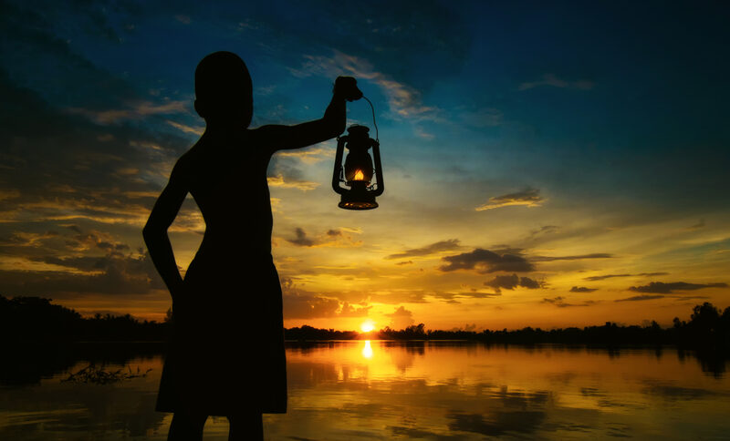 Child holding lamp in the dark